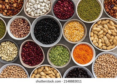 Different types of legumes in bowls, green with yellow peas and mung beans, chickpeas and peanuts, colored beans and lentils, top view - Shutterstock ID 2148883011
