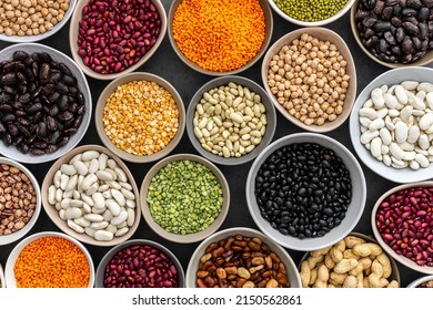 Different types of legumes in bowls, green with yellow peas and mung beans, chickpeas and peanuts, colored beans and lentils, top view - Shutterstock ID 2150562861
