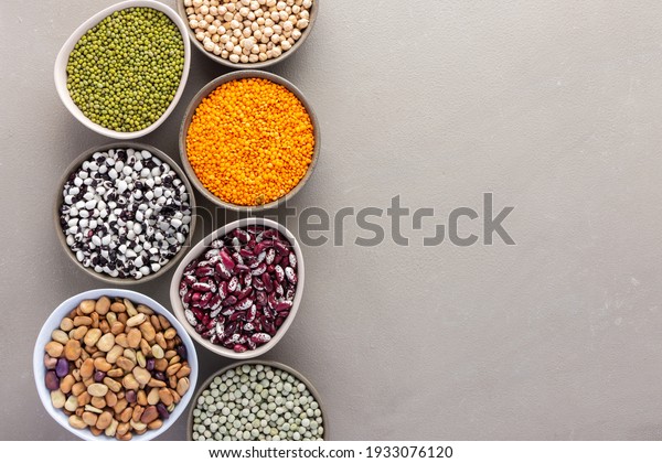 Different types of legumes in bowls, green and\
yellow peas, chickpeas and peanuts, colored beans and lentils, mung\
beans and beans, top\
view