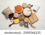 Different types of legumes, cereals and seeds on white wooden table, flat lay