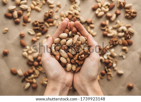 Different types of nuts, nut mix of almonds, hazelnuts, cashews, peanuts in hands. 
