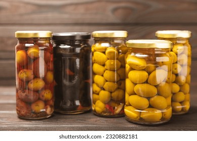 Different types of olives in a jar. Mix.Pickled olives in glass jar. On a wooden background.Tasty olives on wooden table.Close-up.Place for text.Copy space. Delicious healthy mediterranean food.Vegan - Powered by Shutterstock