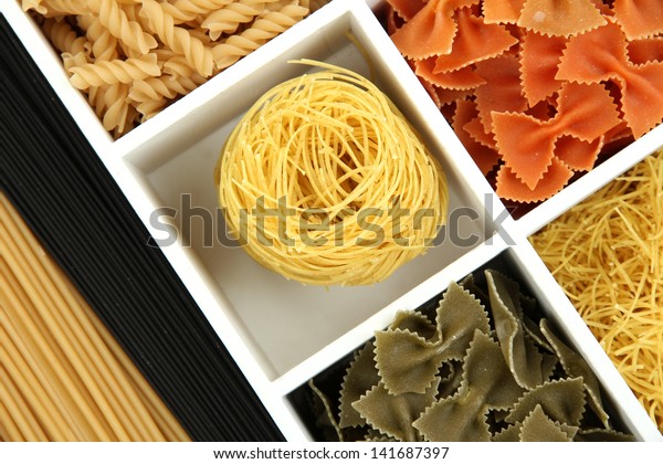 Different types of pasta in white wooden box
sections close-up