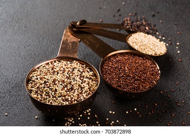 Different types of quinoa, white, red, black and mixed - South american grain - in metal measured spoons