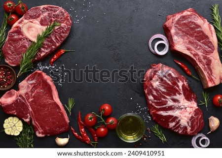 Different types of raw marbled beef steaks : T-bone, ossobuko, spider and rib eye with ingredients for cooking. Top view with copy space.