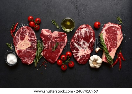 Different types of raw marbled beef steaks : T-bone, ossobuko, spider and rib eye with ingredients for cooking. Top view with copy space.