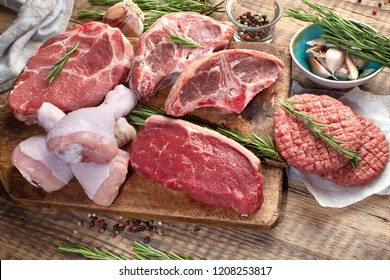 Different types of raw meat - beef, pork, lamb, chicken on a wooden board. - Shutterstock ID 1208253817