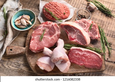Different types of raw meat - beef, pork, lamb, chicken on a wooden board. - Shutterstock ID 1216082338