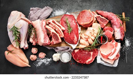 Different types of raw meat - beef, pork, lamb, chicken on dark background. Top view - Shutterstock ID 2233247387