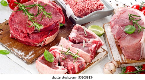 Different Types Of Raw Meat With Fresh Herbs.