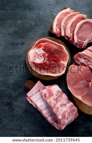 Different types of raw meat on black background. Foods high in protein. Top view, flat lay, copy space
