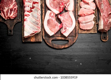 Different Types Of Raw Pork Meat And Beef. On The Black Chalkboard.