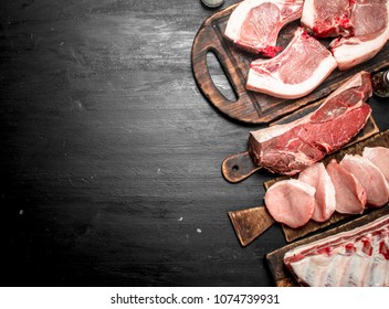 Different types of raw pork meat and beef. On the black chalkboard. - Shutterstock ID 1074739931