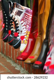 Different Types Of Shoes Lined Up For Sale At An Outdoor Market.