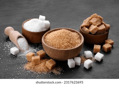 Different types of sugar on black table