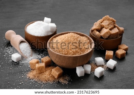 Different types of sugar on black table