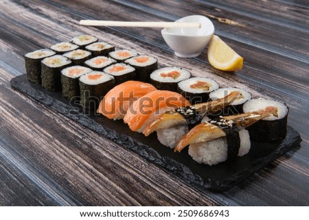 Different types of sushi roll set with salmon, vegetables, fish,eel,  avocado. Menu sushi with nigiri, maki on wooden background