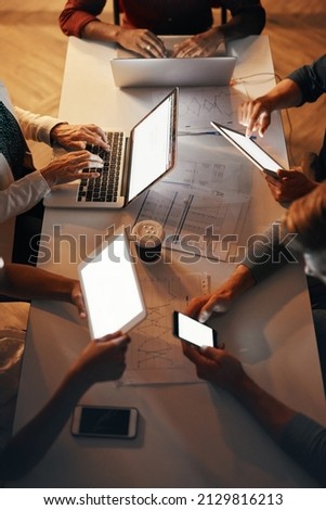Different types of technology can help your business maximize efficiency. High angle shot of a group of designers using modern technology in a meeting.