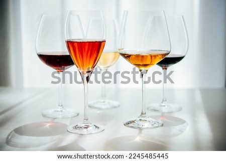 Different types of wine in glasses - red, white, rose and amber. Wine tasting in a bar or restaurant.
