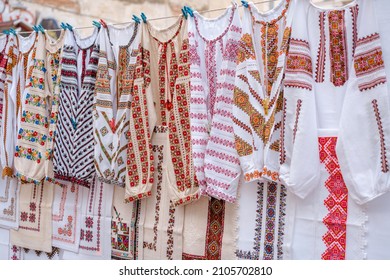 Different Ukrainian vintage clothes - traditional embroidered shirts, vyshyvanka. Traditional ukrainian dresses on flea market Vernissage in Lviv, thrift shopping concept. Selective focus - Shutterstock ID 2105702810