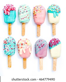 Different variants of cake pops with ice cream shapes on white background 