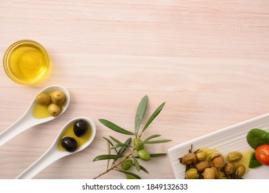 Different Variants Of Olives To Eat And Oil In Containers On Wooden Kitchen Bench. Top View.