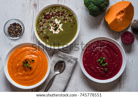 Different vegan food. Colorful vegetables cream soups and ingredients for soup. Healthy eating, dieting, vegetarian kitchen and cooking concept. Top view