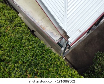 Different Viewpoint Of A Gutter And Roofing Of A Residential House With Hedges On Side