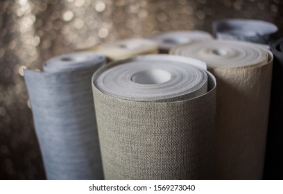 Different wallaper rolls. Various textures and colours. Display of wallpapers. Selection.