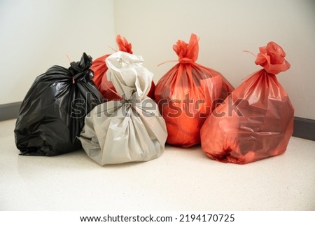 Different waste bag on white floor background,Red, black and grey bags waste on white background.Garbage bags in hospital.Infectious control concept.