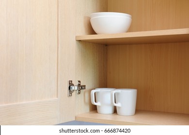Different white dishes in cupboard in the kitchen