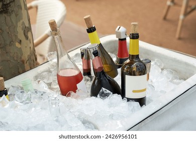 Different wine bottles set in ice bucket on a summer terrace - Powered by Shutterstock