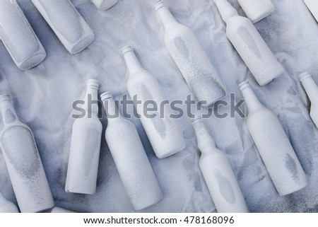 Different wine vodka bottles covered with white acrylic paint. On a white background. Excellent bar background. Creative decor. Secured by modern style.