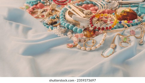 different women's jewelry on blue fabric