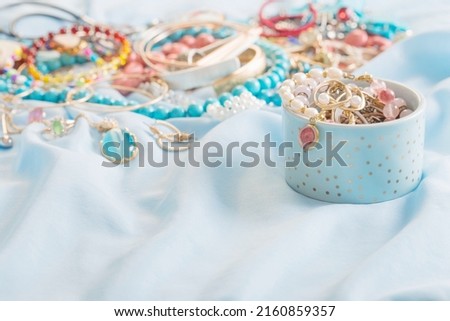 different women's jewelry on blue fabric