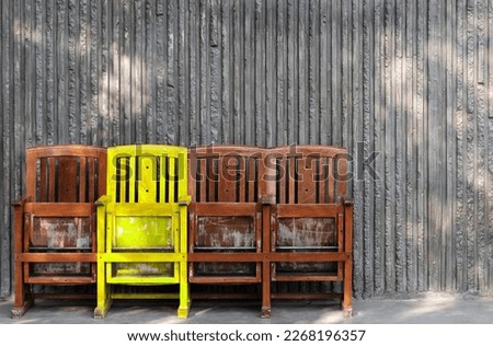 Different yellow wooden chair. Think differently concept