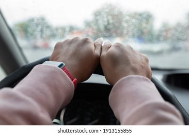 Difficult Road In Bad Rainy Weather. Hands Of Young African American Or Mixed Race Lady With Smartwatch On Steering Wheel, Lady Drives Car In City, View Of Window With Drops, Pov, Copy Space, Close Up