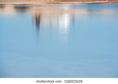 Diffuse reflection of silver car in rippled pool