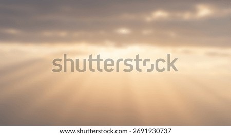 Diffuse sunlight streams through hazy clouds creating soft atmospheric rays
