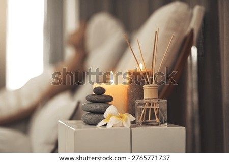 Diffuser, candles or stack of rocks in spa, aromatherapy treatment or soothing atmosphere for relaxation. Peace, burning scent or fragrance setup on table in wellness center, person or zen ambient