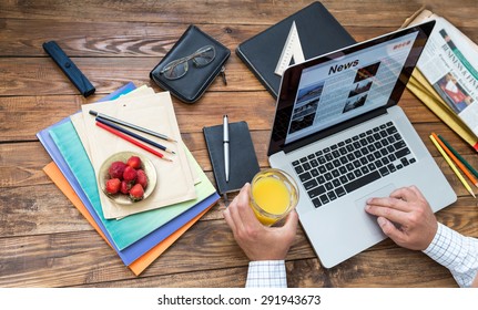 Digesting The News Concept. Countryside Working Room Vintage Wooden Desk Laptop Digital News Internet Page Opened On Screen Man Top View Working Keyboard Drinking Juice Business Items Creative Mess