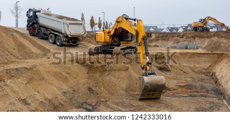 digger and truck working in excavation pit