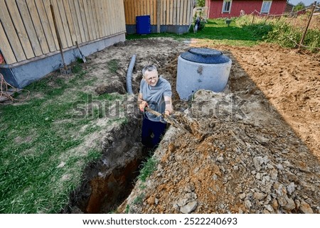 Digger worker digs an absorption trench for filtration field und