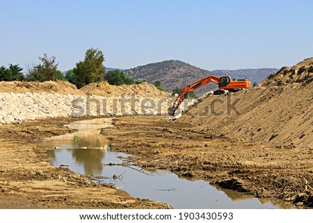 a digger working on half dried watercourse