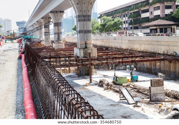 Digging and construction of tunnel\
underpass underway beneath train line within city\
setting
