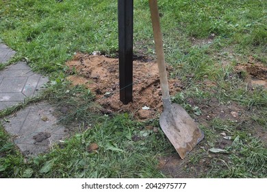 Digging A Metal Post For Fence On The Border Of The Plot, Outdoor Image                               