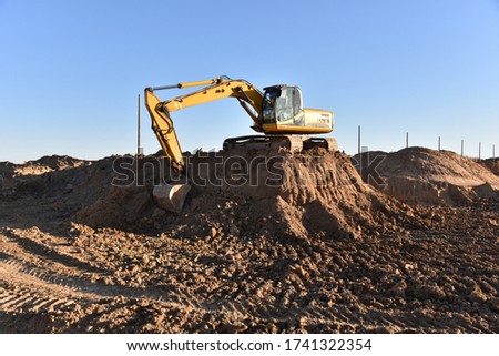 Digging the pit foundation a hole with excavator. Earthwork in excavation and backfilling of soil upto required depth is required for construction of trenche. Construction machinery for earthmoving
