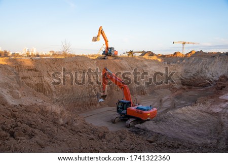 Digging the pit foundation a hole with excavator. Earthwork in excavation and backfilling of soil upto required depth is required for construction of trenche. Construction machinery for earthmoving
