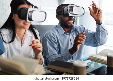 Digital 3d virtual technology. Education with modern gadgets and technologies. Happy smiling positive two friends, Asian girl and African man, moving hands while trying VR goggles - Powered by Shutterstock