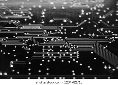 Digital AI, Artificial Intelligence or machine learning background concept, closed up of computer circuit board with solder on black surface.